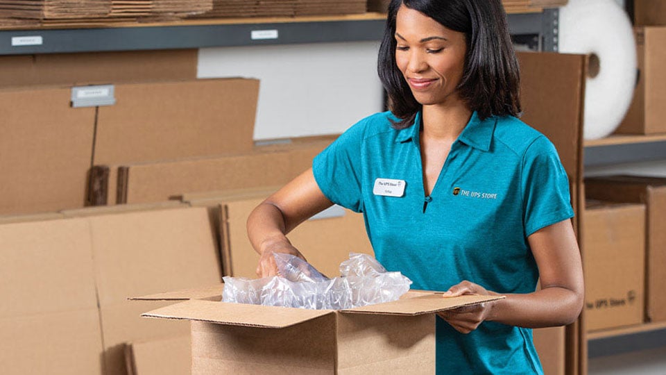 The Shipcora Logistics Store employee packing a shipment.
